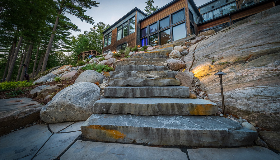Natural granite stonework integrated into Canadian Shield cottage landscape