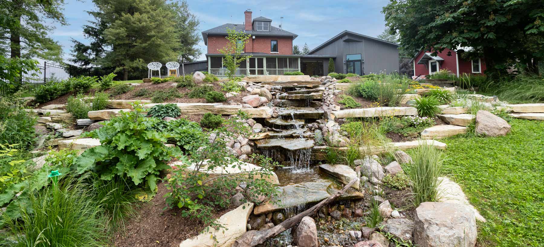 Natural stone water feature and completed landscape project by Shades of Green Landscapes